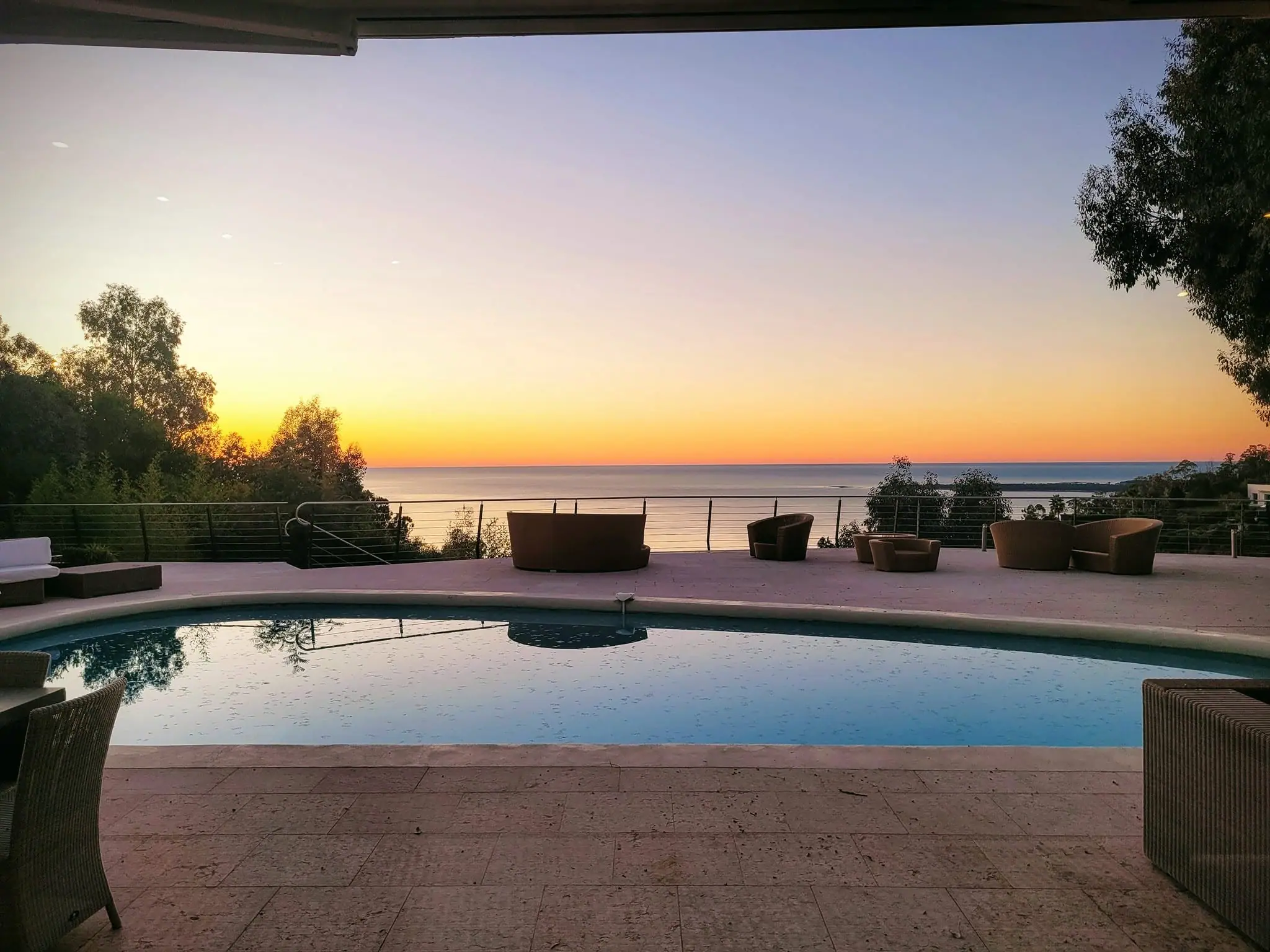Sunset reflected across the pool at Villa Oxygène