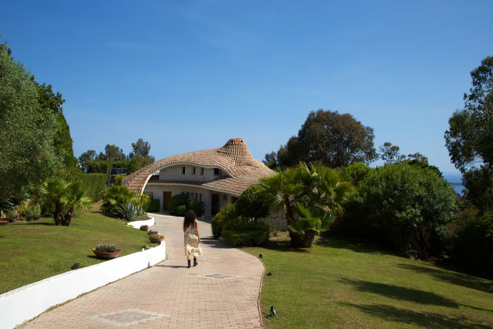 The landscaped drive descending toward Villa Oxygène
